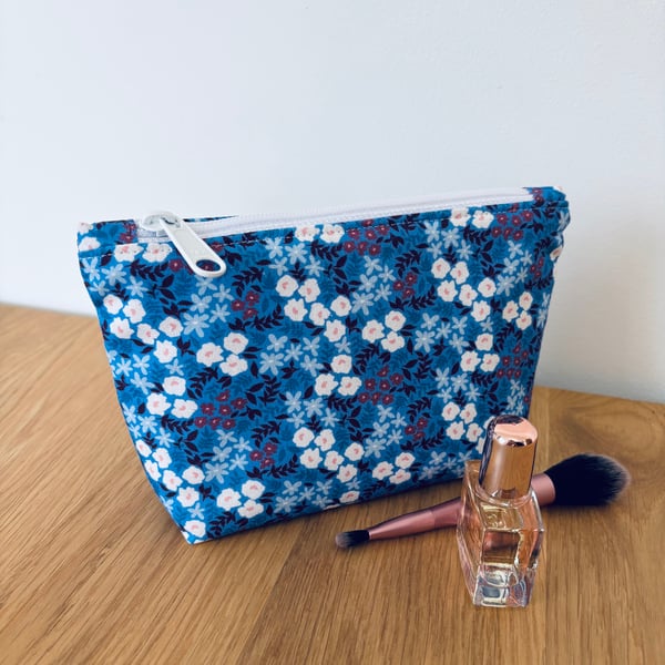 Small cotton makeup bag, pouch, purse, in blue and purple floral design.