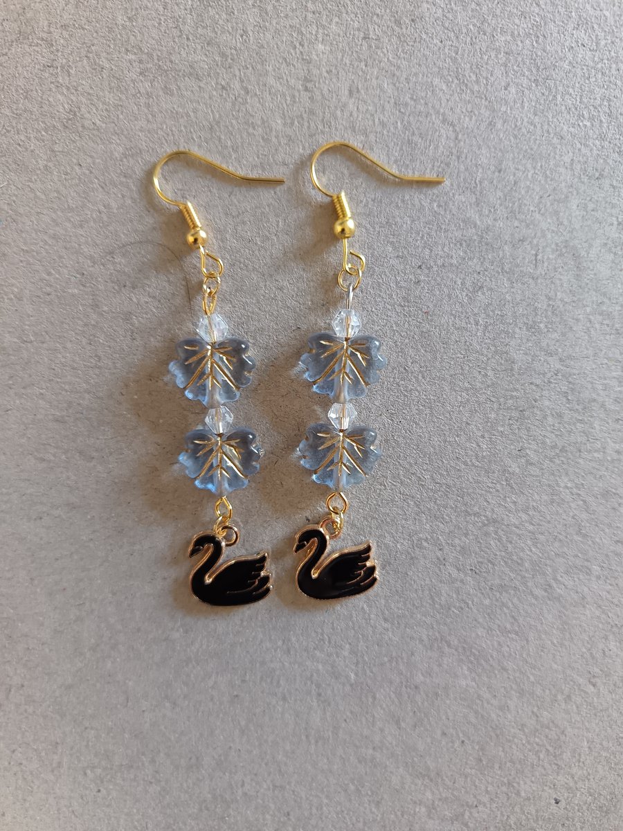 Black and gold swan charm dangle earrings with blue leaf beads