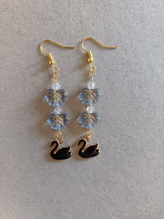 Black and gold swan charm dangle earrings with blue leaf beads