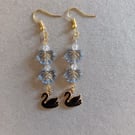 Black and gold swan charm dangle earrings with blue leaf beads