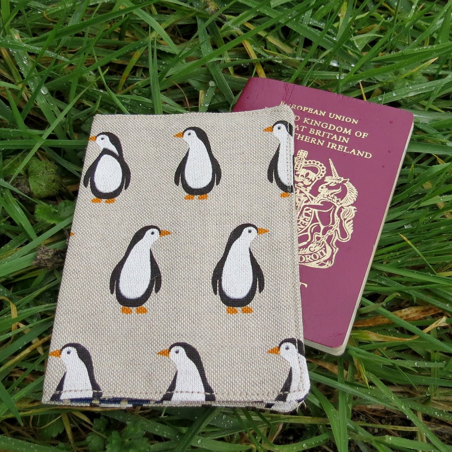 A passport sleeve with a penguin design.  Passport cover.