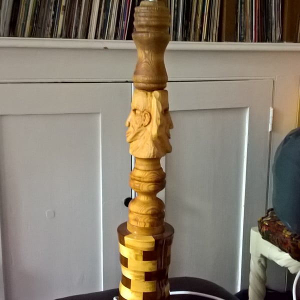 A table lamp with Hand carved faces and eclectic phases, 720 mm tall