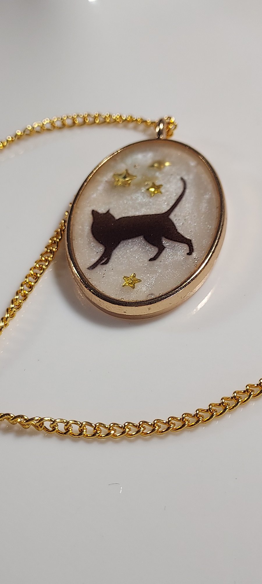 Oval resin pendant necklace with black cat and stars