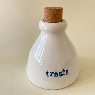 Ceramic treats bottle with tall cork.