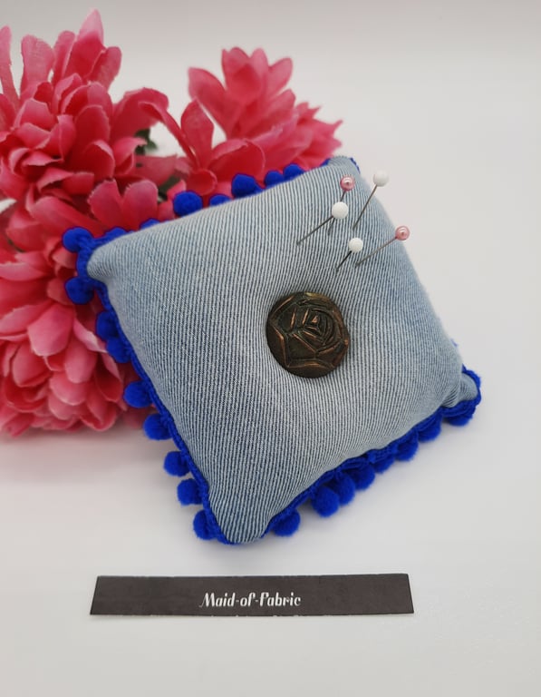 Pin cushion in upcycled denim with blue bobble trim and a rose button. 