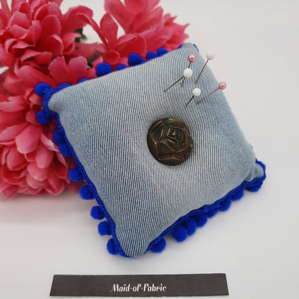 Pin cushion in upcycled denim with blue bobble trim and a rose button. 