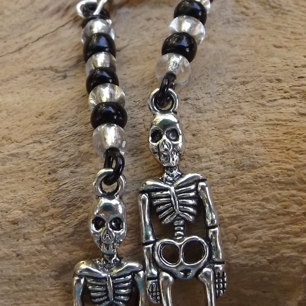 Black and white seed beaded dangle skeleton charm earrings
