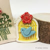 Little ceramic bird cage brooch with flower. Pottery jewellery