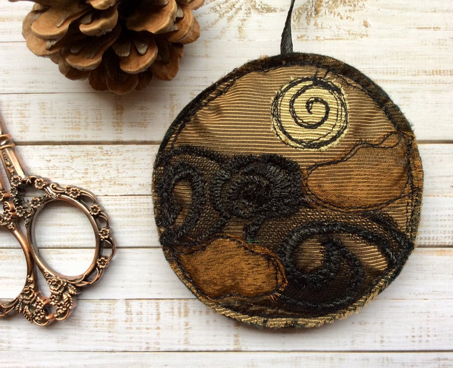 Upcycled embroidered gold decoration. 