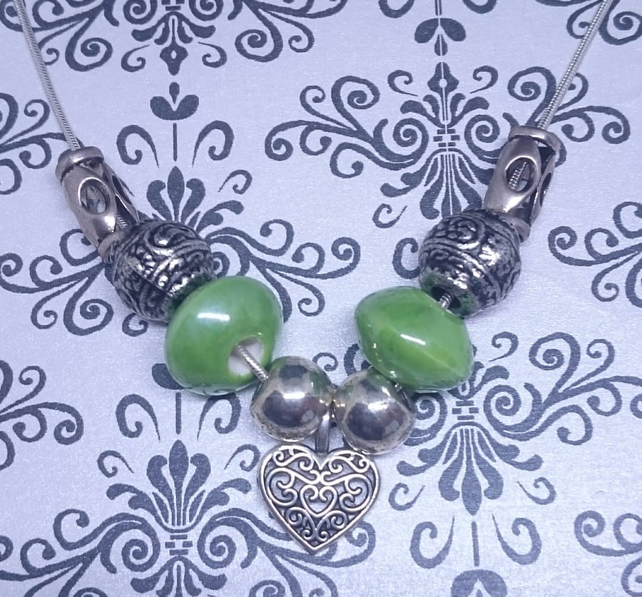 Eclectic Beaded Necklace With Ceramic Beads and a Silver Heart.