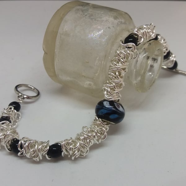 BR186  Scrunched chain link bracelet with black beads.
