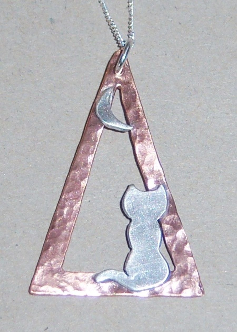 Pendant with a silver cat in  a copper triangle