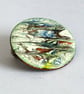 medium round brooch - scrolled red, yellow, black, blue on white - Image 1