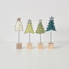 A Christmas Tree with a Wire Stem and Wooden Block Stand