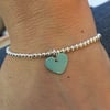 Turquoise enamel heart on silver beaded stretch bracelet. Stacking bracelet.