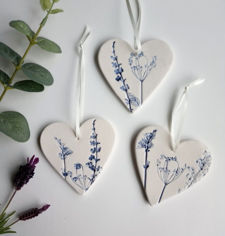 Set of 3 ceramic heart hangings with a botanical print.