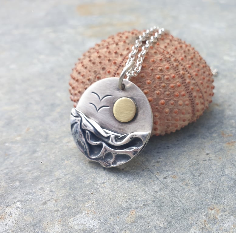Circular silver, sea coast sunrise pendant, with brass sun and seagulls