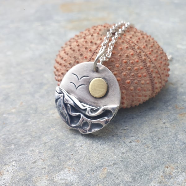 Circular silver, sea coast sunrise pendant, with brass sun and seagulls