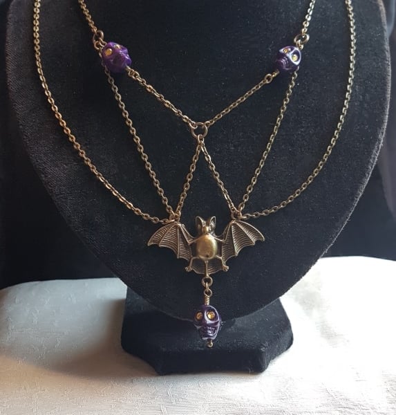 Spooky Antique Bronze Bat Necklace with Purple Skulls.