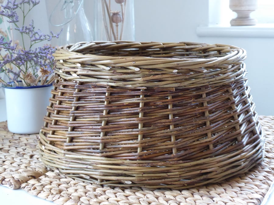 A round handmade willow basket with tapered sides