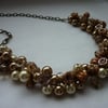 SHADES OF CREAM, GOLDS AND BRONZE CLUSTER NECKLACE.  463