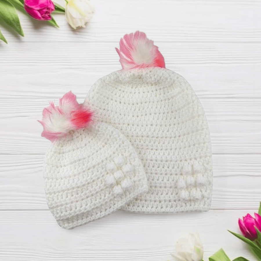 Matching ladies and baby white crocheted hats with detachable faux fur pompoms 