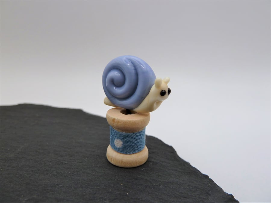 small snail on a wooden bobbin