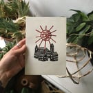 Zenith, folk linocut print village and sun on paper