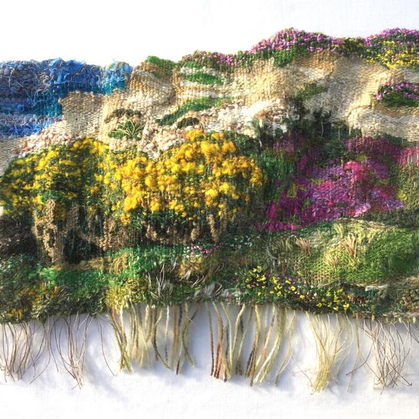 Hand woven 3D tapestry landscape in shades of green, pink, yellow and blue