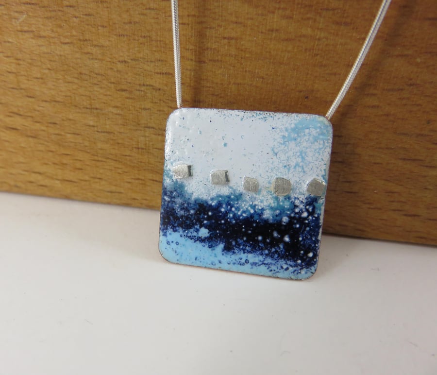 Square copper necklace pendant with blue and white enamel and silver peg detail.