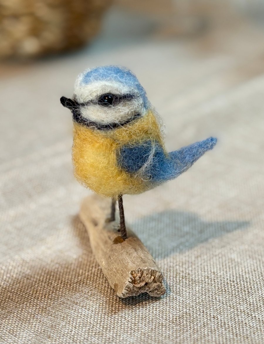 Needle felt mini bluetit sitting on driftwood 