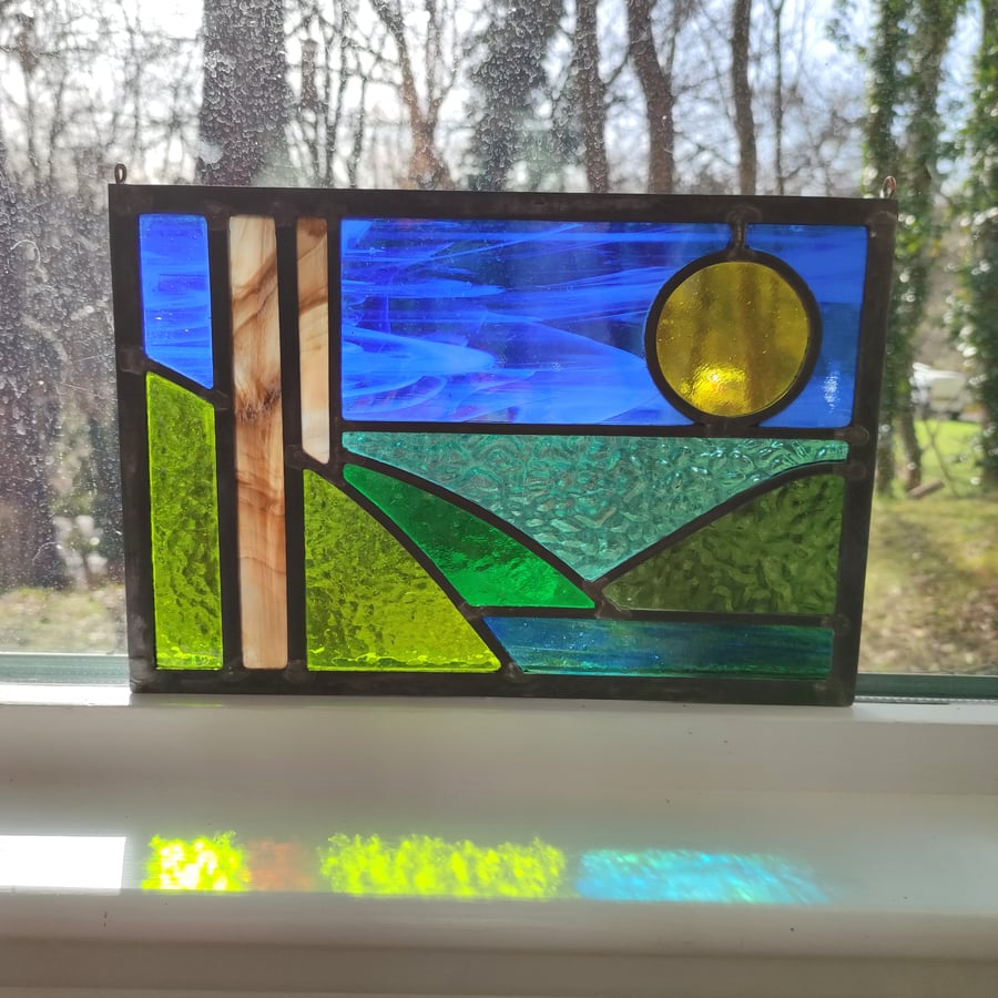 Stylised stained glass landscape bold couloured textured leaded panel.