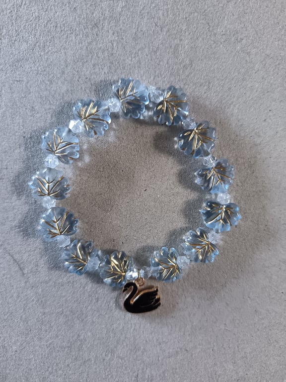 Elasticated black and gold swan charm bracelet with blue leaf beads 