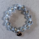 Elasticated black and gold swan charm bracelet with blue leaf beads 