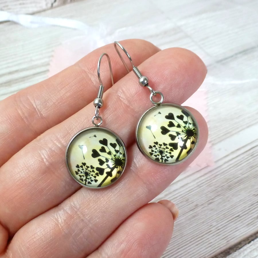 Yellow dangle earrings with heartshaped seedhead design and steel wires. 