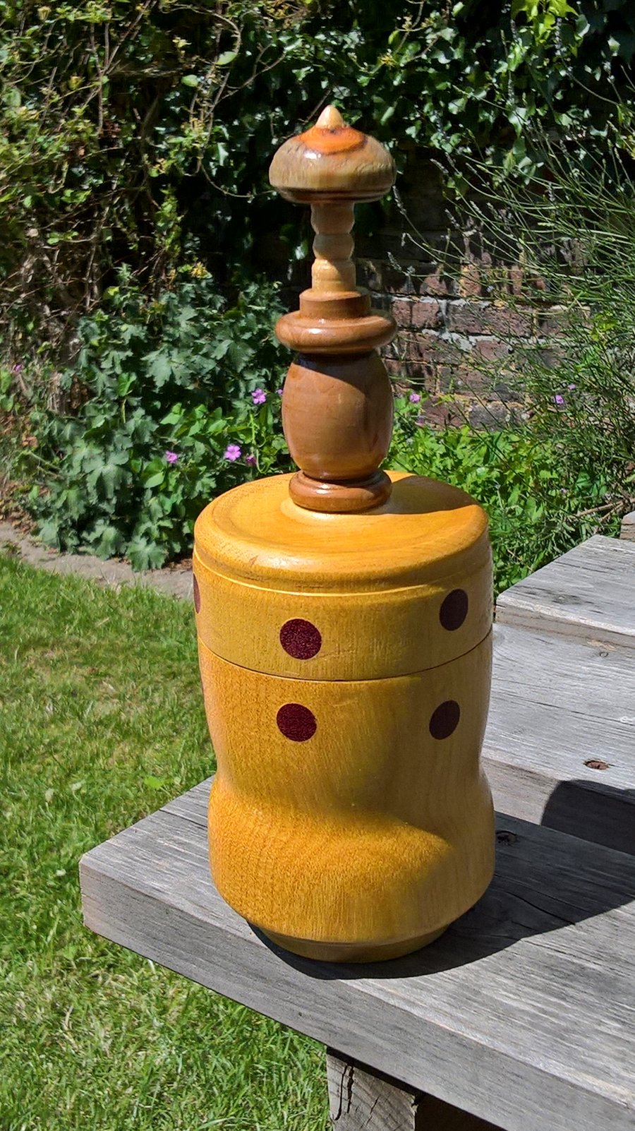  A yellow wooden pot with an orange yew finial and purple dots