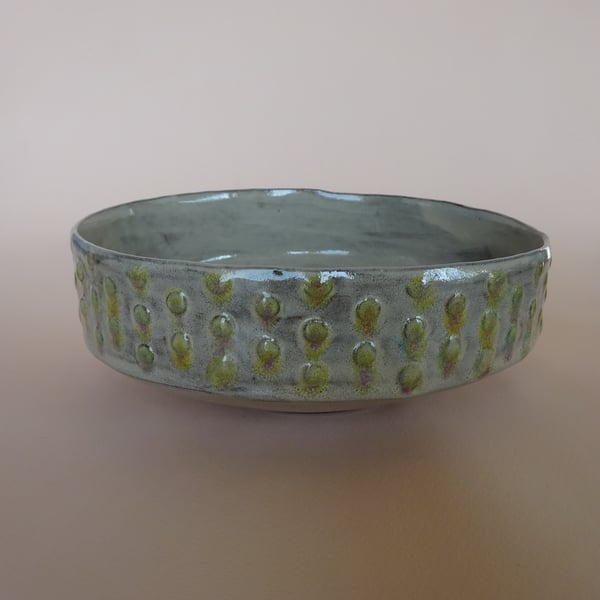 Decorative circular ceramic bowl with spot relief design