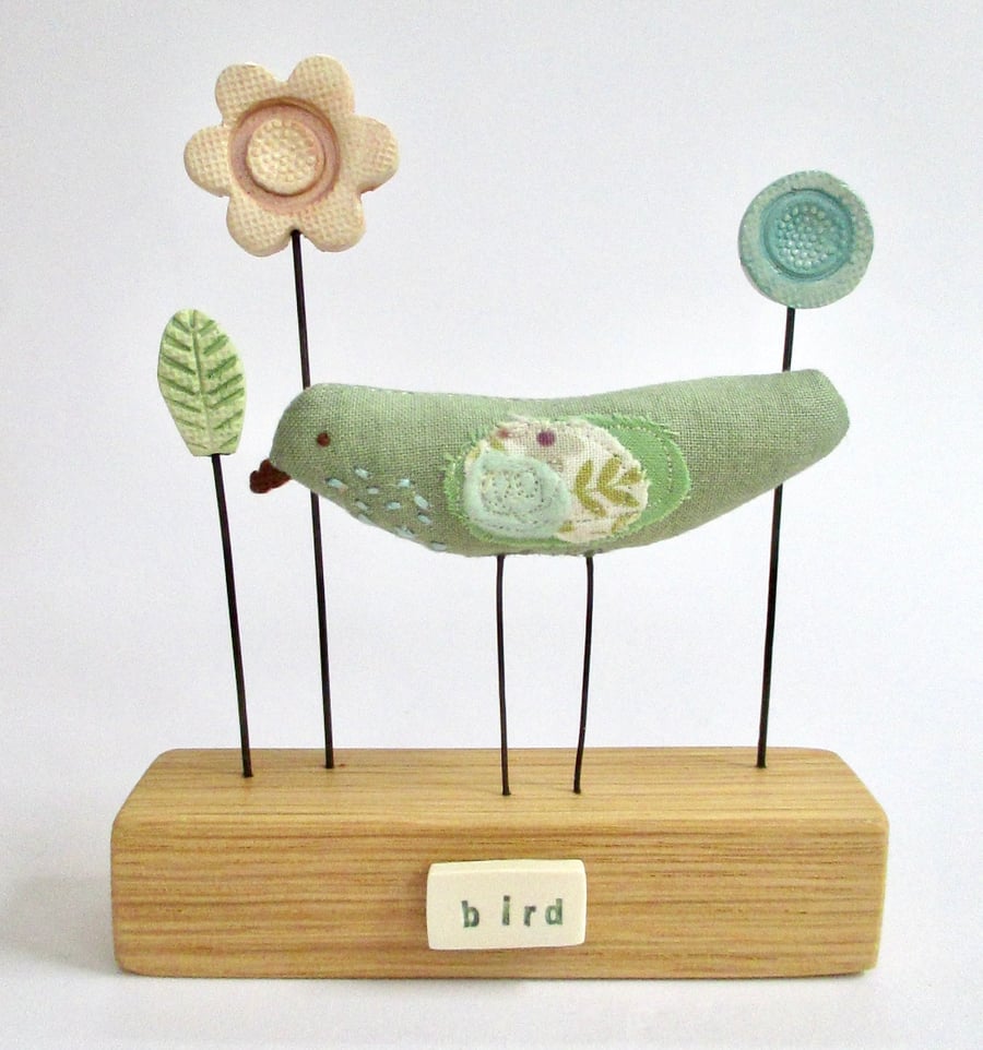Handmade fabric bird with clay flowers