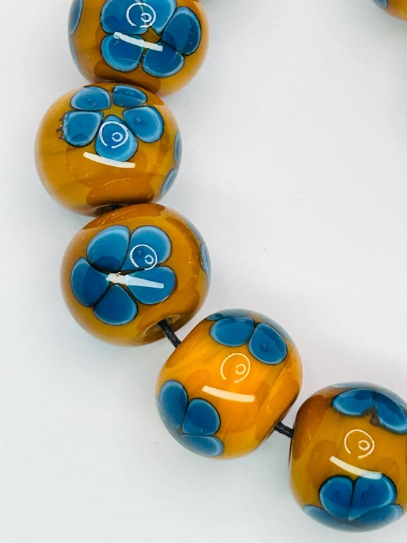 Handmade teal and mustard daisy patterned lamp work glass beads