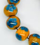 Handmade teal and mustard daisy patterned lamp work glass beads