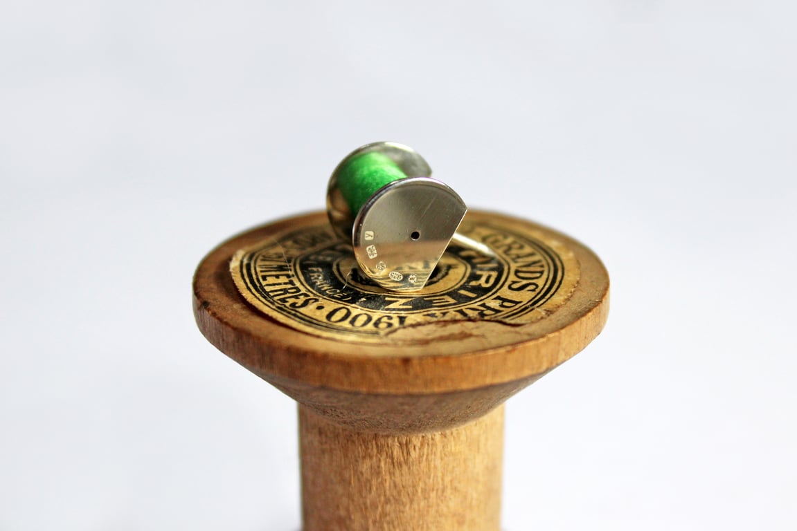 Cotton reel brooch with green thread