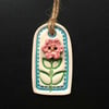 Small blue ceramic tag decoration with flower button