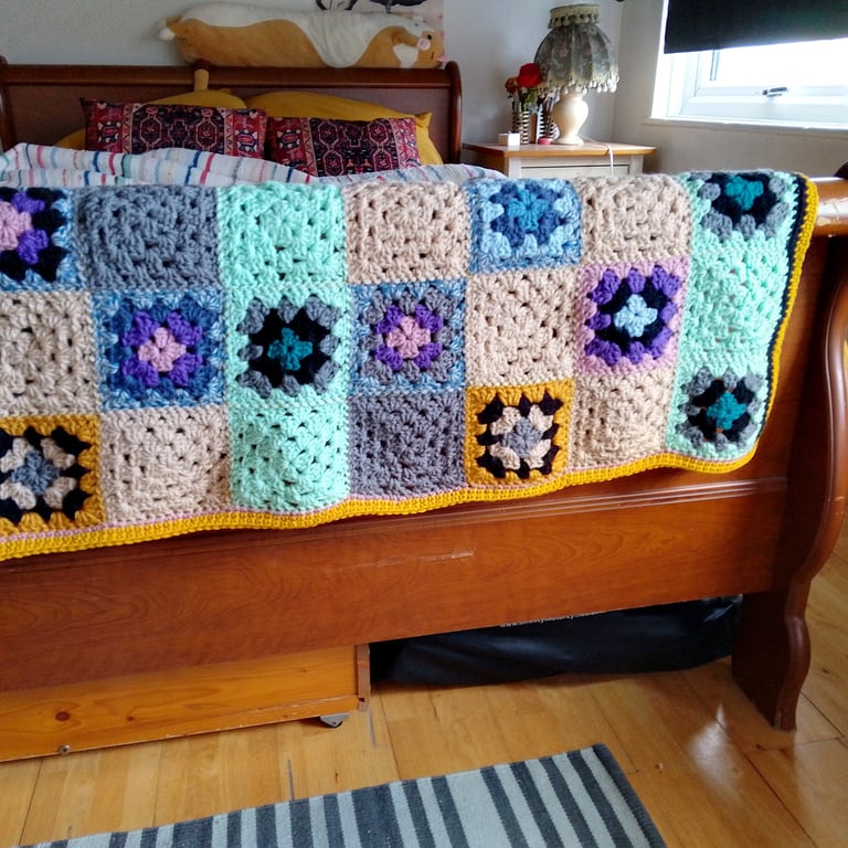 Baby or toddler blanket in a multicoloured theme.