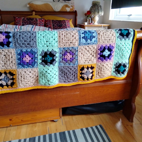 Baby or toddler blanket in a multicoloured theme.