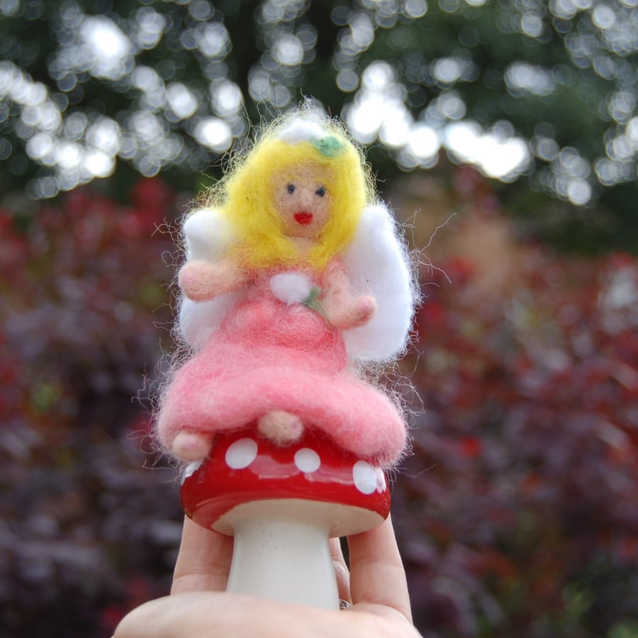 Fairy on a mushroom.   Needle felt mushroom on a ceramic muhroom