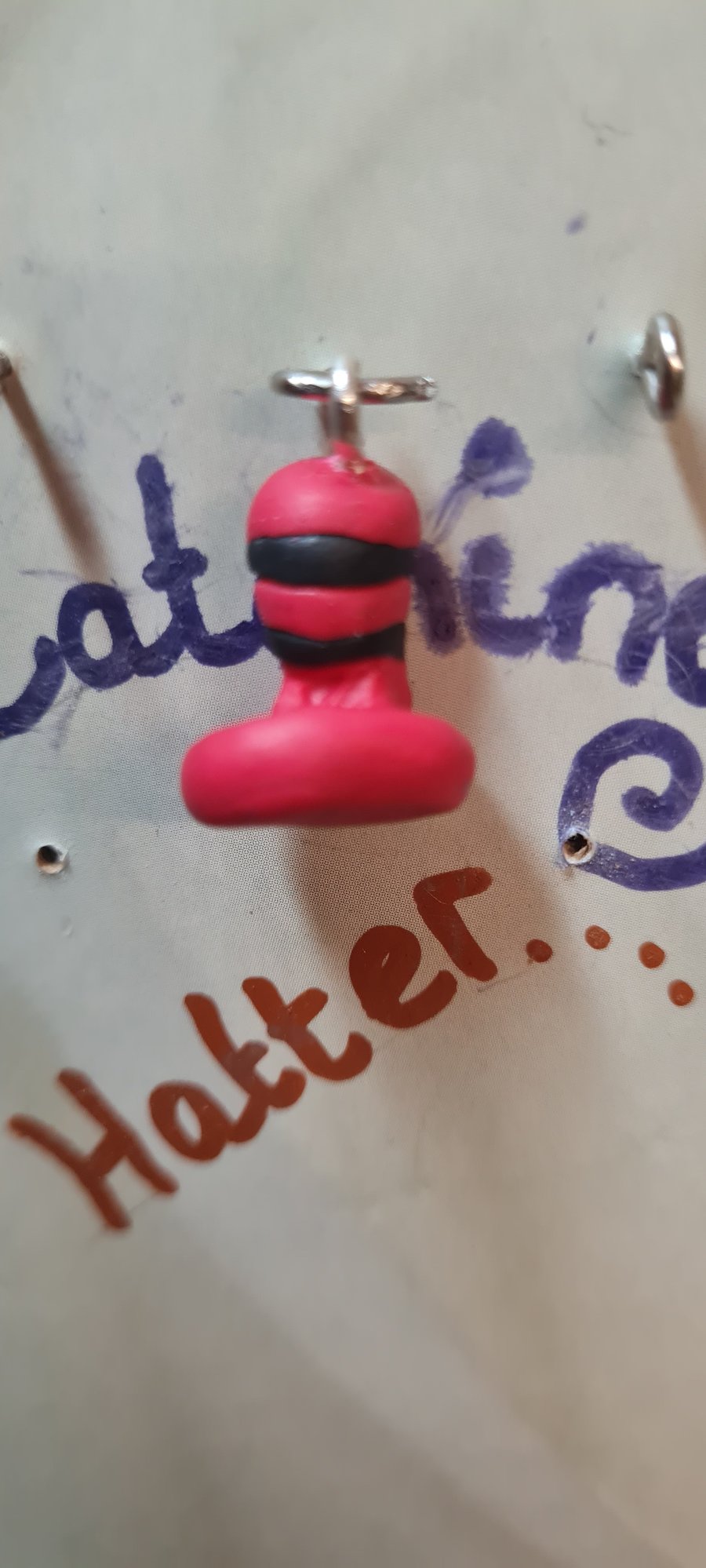 Black and red polymer-clay hat charm.