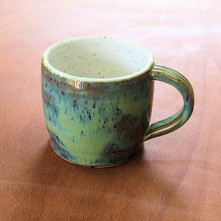 Stoneware pottery mug finished in a muli-colour green glaze