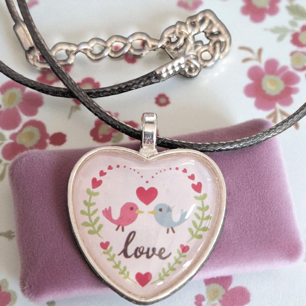 Necklace heart shaped features two birds facing each other with Love 