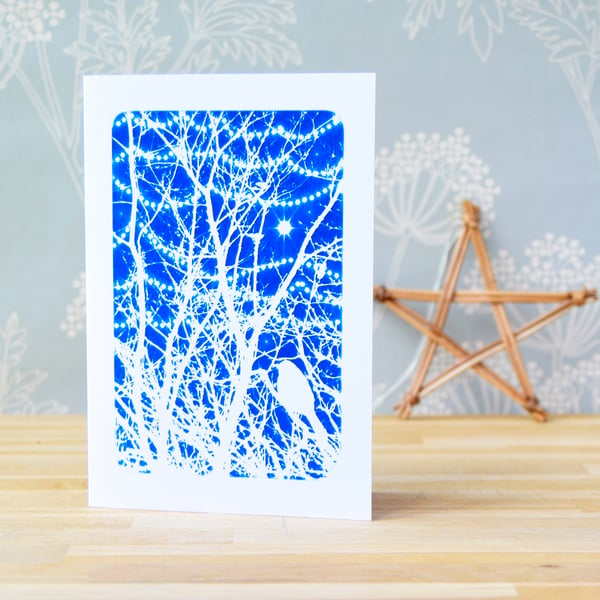 Christmas card with bird in branches and sparkling lights