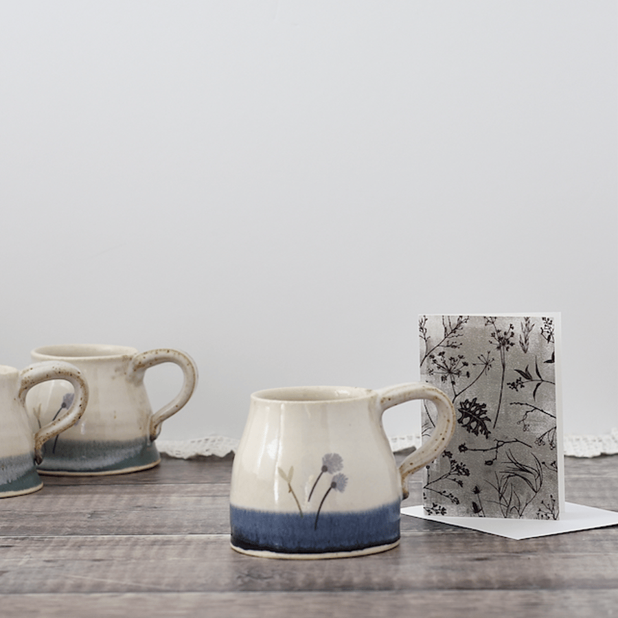 Handmade stoneware ceramic mug with flowers glazed in shades of blue and white
